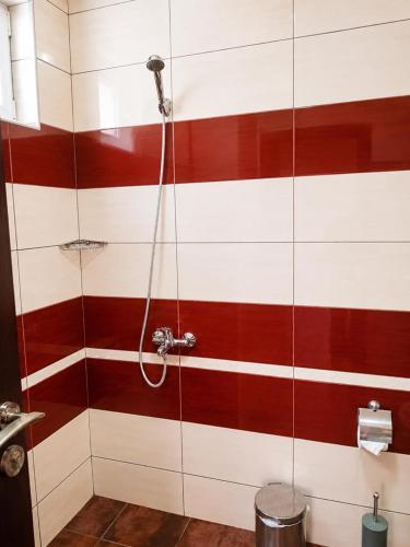 a bathroom with a shower with red and white stripes at Liora studio apartments in Sunny Beach
