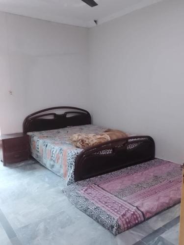 two twin beds sitting in a room at Spacious 2 Bed Room Home Attached Baths, Lounge & Kitchen in Abbottabad