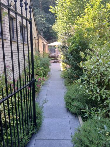 a sidewalk next to a wrought iron fence at Le Loft du Renard, gîte cosy au coeur de la nature boisée à Namur Wépion, une parenthèse douce dans la vallée mosane in Namur