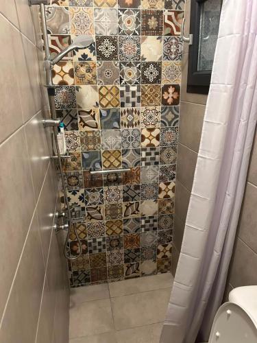 a bathroom with a shower with a tiled wall at Lemnos Nest in Kondiás