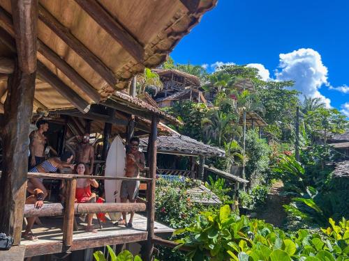 a group of people standing in a building with a surfboard at Pousada Tiririca Surf in Itacaré