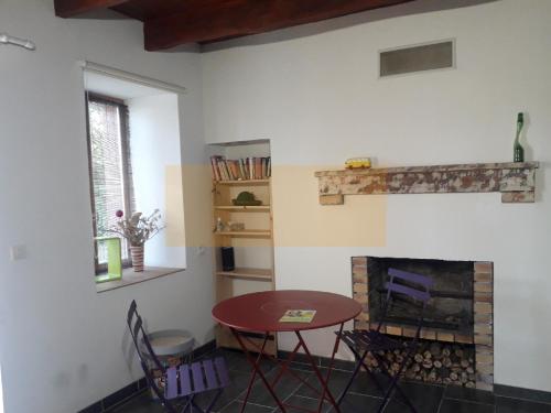 a dining room with a table and a fireplace at Nuit pour 2 en Auvergne in Vallon-en-Sully