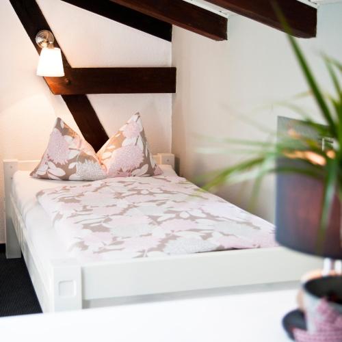 a white bed with a plant in a room at Ferienapartments Spreewaldwiesen in Vetschau