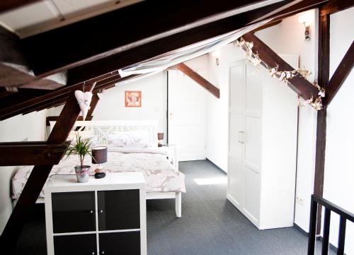 a bedroom with a white bed and a white table at Ferienapartments Spreewaldwiesen in Vetschau
