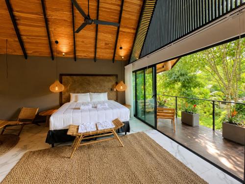 a bedroom with a large bed and a balcony at Namu Garden Hotel & Spa - Adults Only in Puerto Viejo