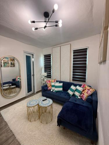 a living room with a blue couch and two tables at Monterosso By Cinque Terre in Isabela