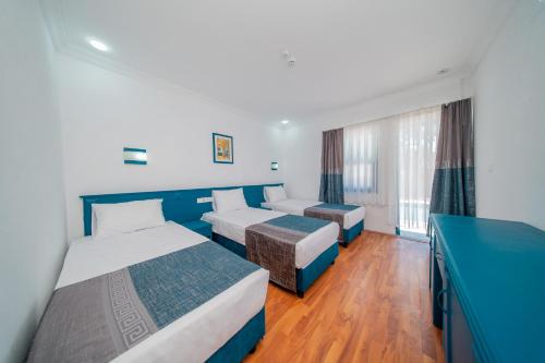 a hotel room with two beds and a window at Forest Garden in Goynuk