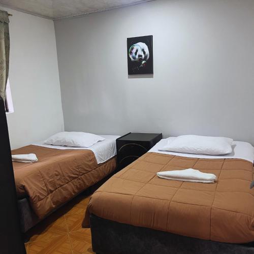 a room with two beds and a picture on the wall at Casa la Colina in Macanal