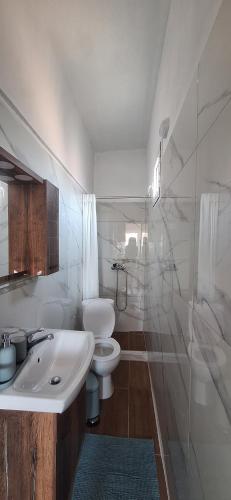 a white bathroom with a toilet and a sink at Imeros Summer Home 3 in Ímeros