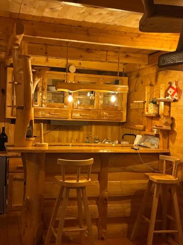 a bar in a wooden room with two stools at JUSA ჯუსა in Kantauri