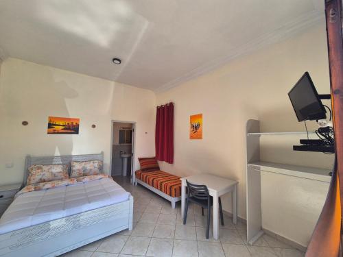 a bedroom with a bed and a couch and a desk at Terre d'Océan in Taghazout