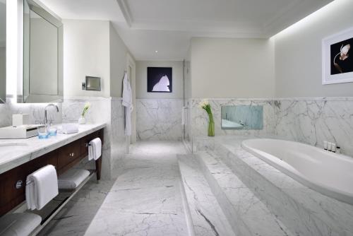 a bathroom with a tub, sink, and toilet at Address Boulevard in Dubai