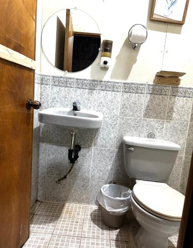 a bathroom with a toilet and a sink and a mirror at Xitlaly cabins in La Montaña