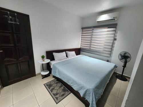 a small bedroom with a bed and a window at SBJ Place East Legon in Accra