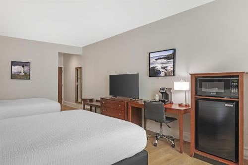 a hotel room with a bed and a desk with a computer at Best Western Plus Brunswick Bath in Brunswick