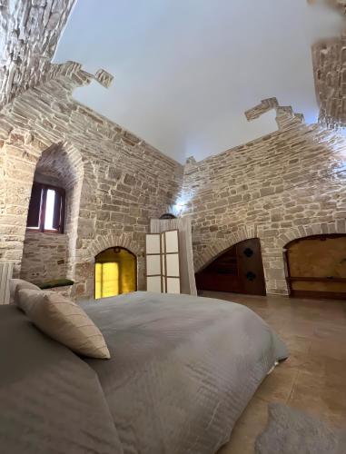 a bedroom with a large bed in a stone wall at Apulia Luxury House in Toritto
