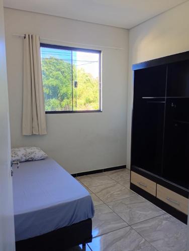 a bedroom with a bed and a large flat screen tv at Quartos Residencial Arcos in Arcos