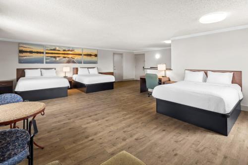 a hotel room with two beds and a table and chairs at Days Inn by Wyndham Mt. Vernon in Mount Vernon