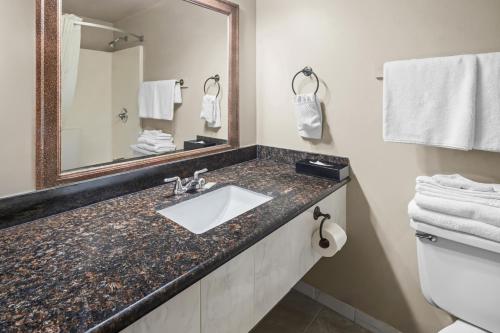 a bathroom with a sink and a mirror and towels at Days Inn by Wyndham Mt. Vernon in Mount Vernon