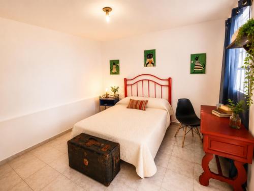 a bedroom with a bed and a table and a chair at Casa Galia in Morelia