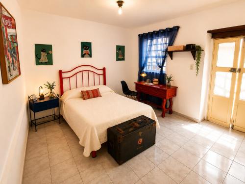 a bedroom with a bed and a table and a desk at Casa Galia in Morelia