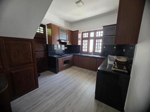a large kitchen with wooden floors and wooden cabinets at Villa at 37 in Badulla