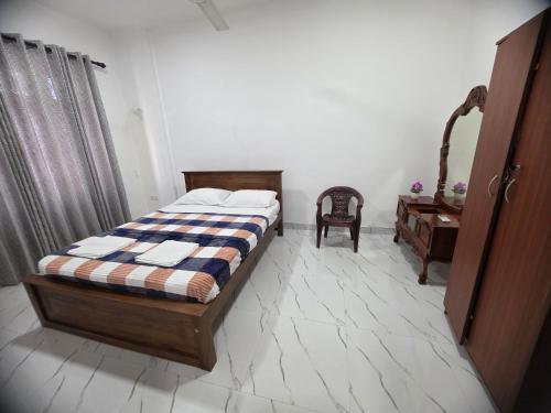 a bedroom with a bed and a table and a chair at Villa at 37 in Badulla