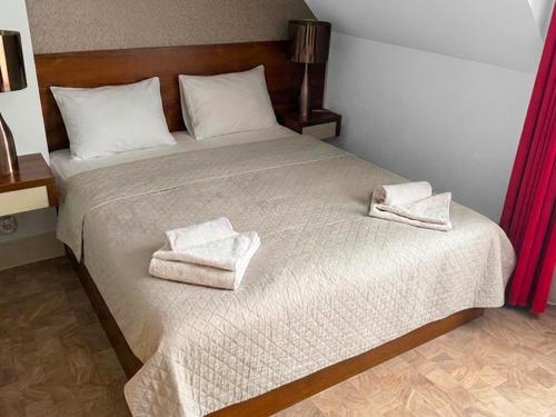 a bedroom with a bed with two towels on it at Apartamenty Mesa Grill Restaurant Cafe in Dźwirzyno