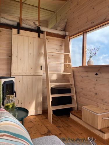 a tree house with a ladder in a room at TinyHouse pod Tatrami in Nižná Šuňava