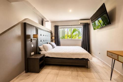 a bedroom with a large bed and a window at Villa Ellia - Terres Basses in Les Terres Basses