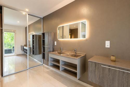 a bathroom with a sink and a mirror at Villa Ellia - Terres Basses in Les Terres Basses
