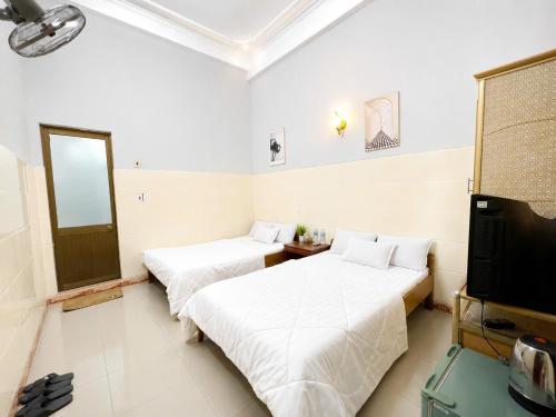 a room with two beds and a television in it at ĐAN MY Motel in Dong Hoi