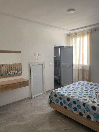 a bedroom with a bed and a refrigerator at Ain grenz in Kelibia