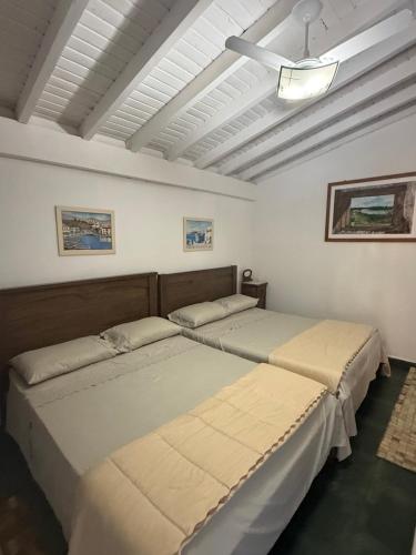 two beds in a white room with a ceiling at VILLA ARATOCA in Garça