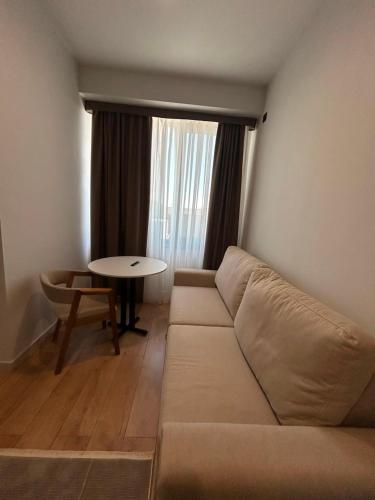 a living room with a couch and a table at Raduga West Apart Hotel in Koshkolʼ