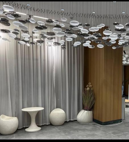 a chandelier in a room with two tables and chairs at Raduga West Apart Hotel in Koshkolʼ