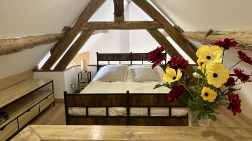 a bedroom with a bed with a vase of flowers at À la Pays Anes in Tannerre-en-Puisaye