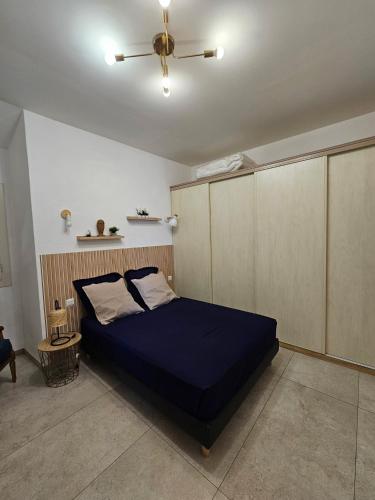 a bedroom with a blue bed and a ceiling fan at Dolce e Lumiu in Lumio