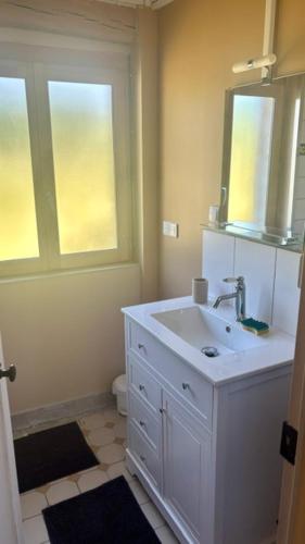 a white bathroom with a sink and a window at À la Pays Anes in Tannerre-en-Puisaye