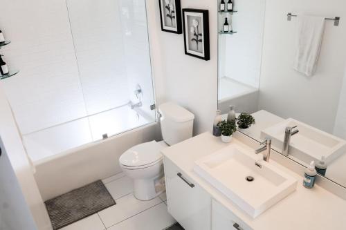 a white bathroom with a toilet and a sink at Modern Studio by Brickell & Beach in Miami