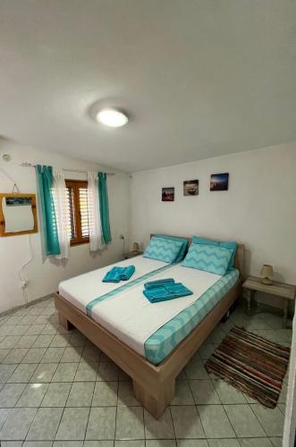 a bedroom with a large bed with blue pillows at Vila Maša in Utjeha