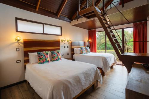 a bedroom with two beds and a staircase in it at Green Forest Rustic Houses in Monteverde Costa Rica
