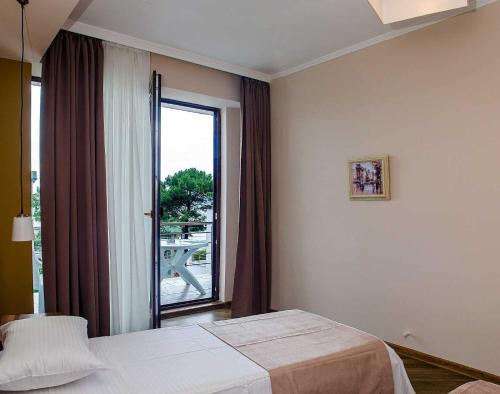 a hotel room with a bed and a large window at Resolute Shekvetili Hotel in Shekhvetili