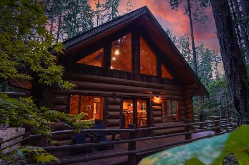 a log cabin in the woods at dusk at Wilderness Retreat in Glacier
