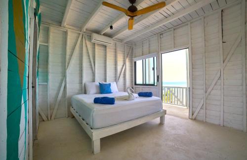 a bedroom with a bed with a view of the ocean at El Faro Beach Front by ÓOL Hotels in Holbox Island