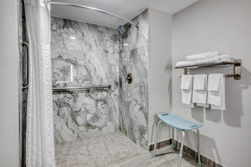 a bathroom with a marble shower with a blue stool at Best Western Lake Okeechobee in Okeechobee