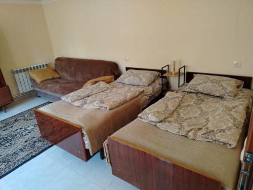 two beds in a room with a couch and a couch at Mashtots B&B in Vanadzor