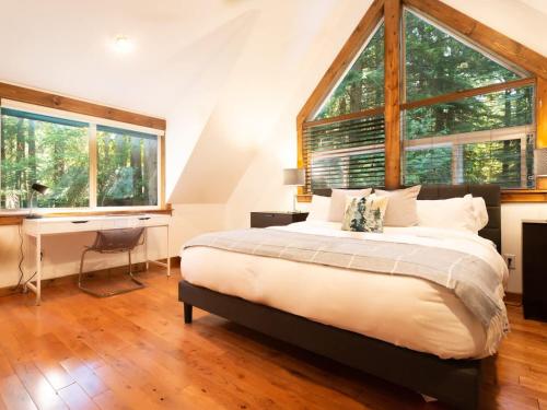 una camera da letto con un letto, una scrivania e finestre di Wild Goose Lodge a Glacier
