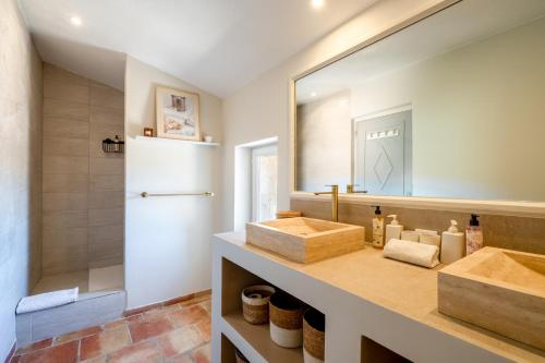 a bathroom with two sinks and a large mirror at Mas Oréa Sous la glycine in Gordes