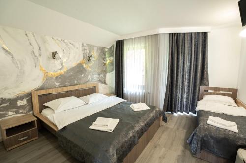 a bedroom with two beds with towels on them at Vila Popasul Dacilor in Grădiştea de Munte